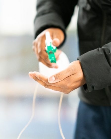 person in black jacket holding green and white plastic bottle