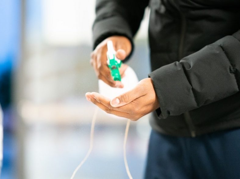 person in black jacket holding green and white plastic bottle