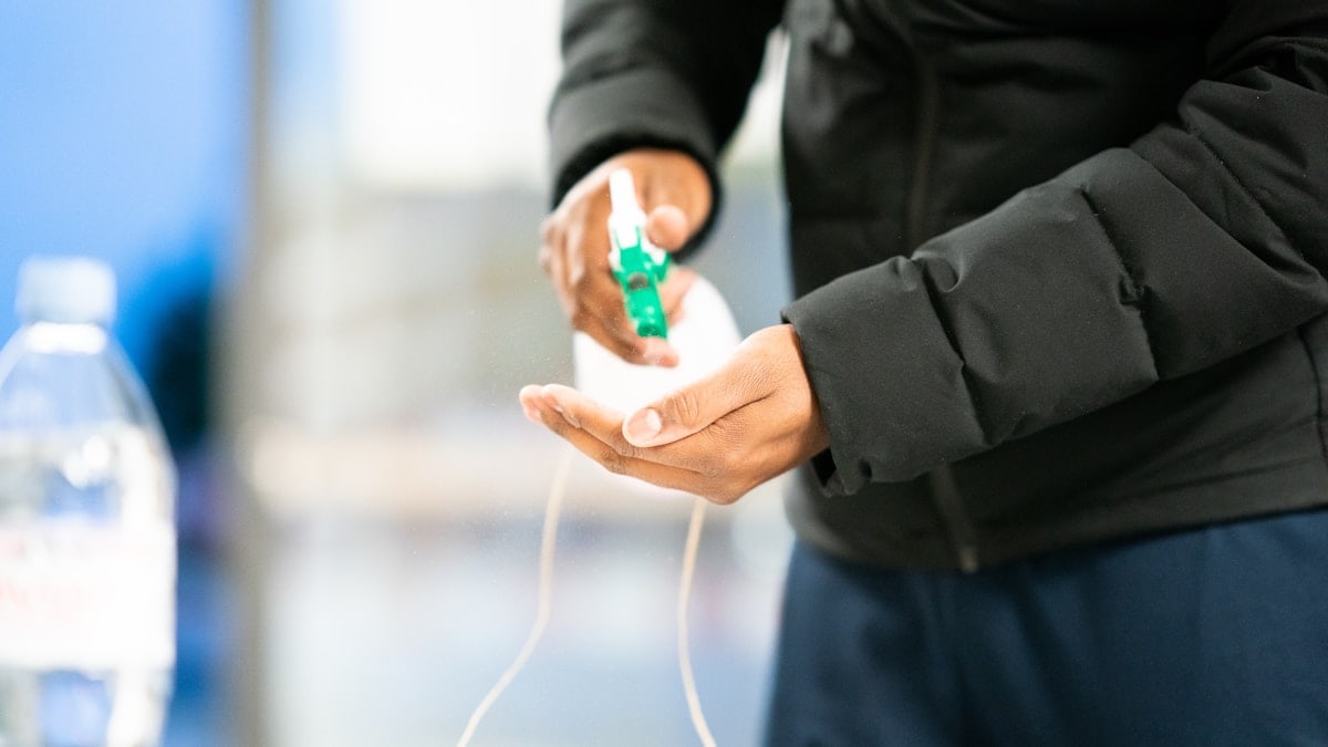 person in black jacket holding green and white plastic bottle